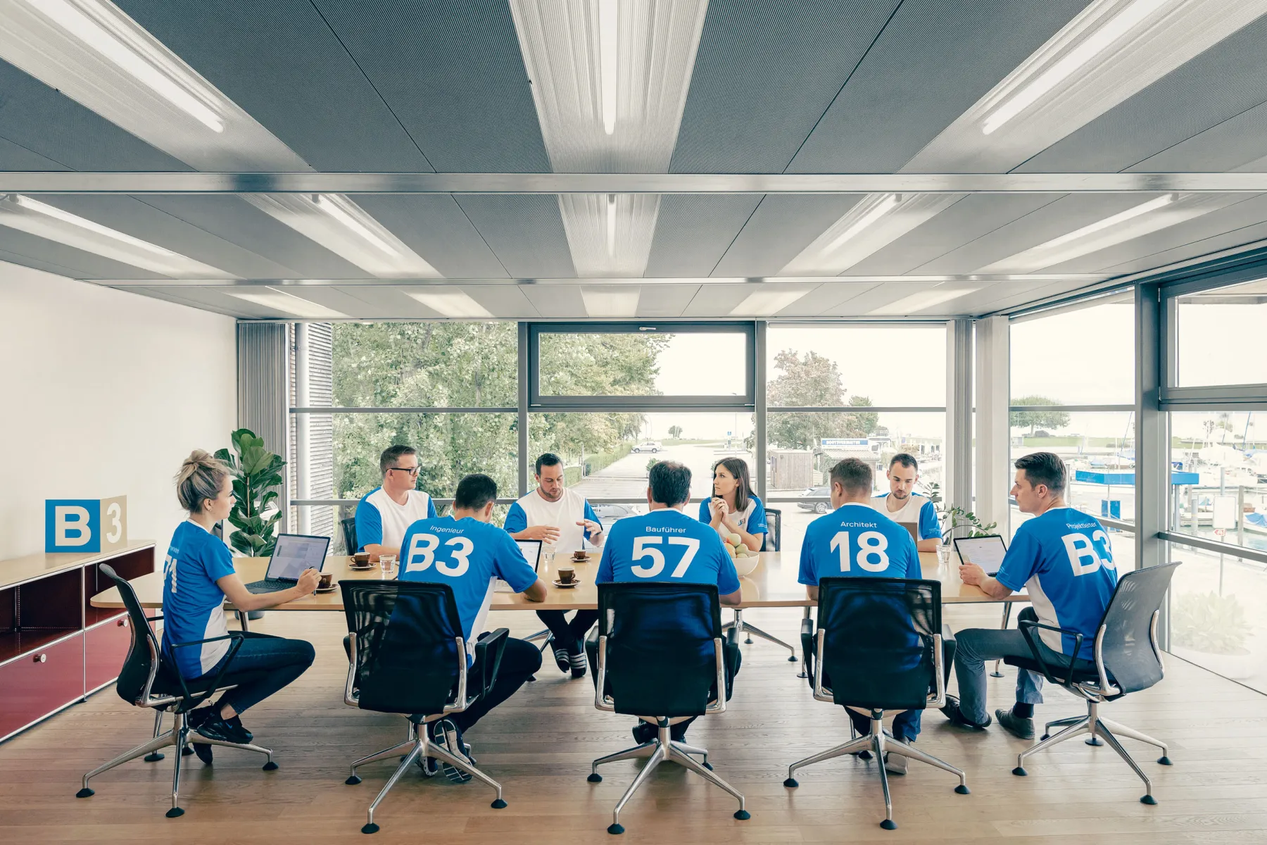 Viele Menschen sitzen in einem Raum und tragen das gleiche T-Shirt