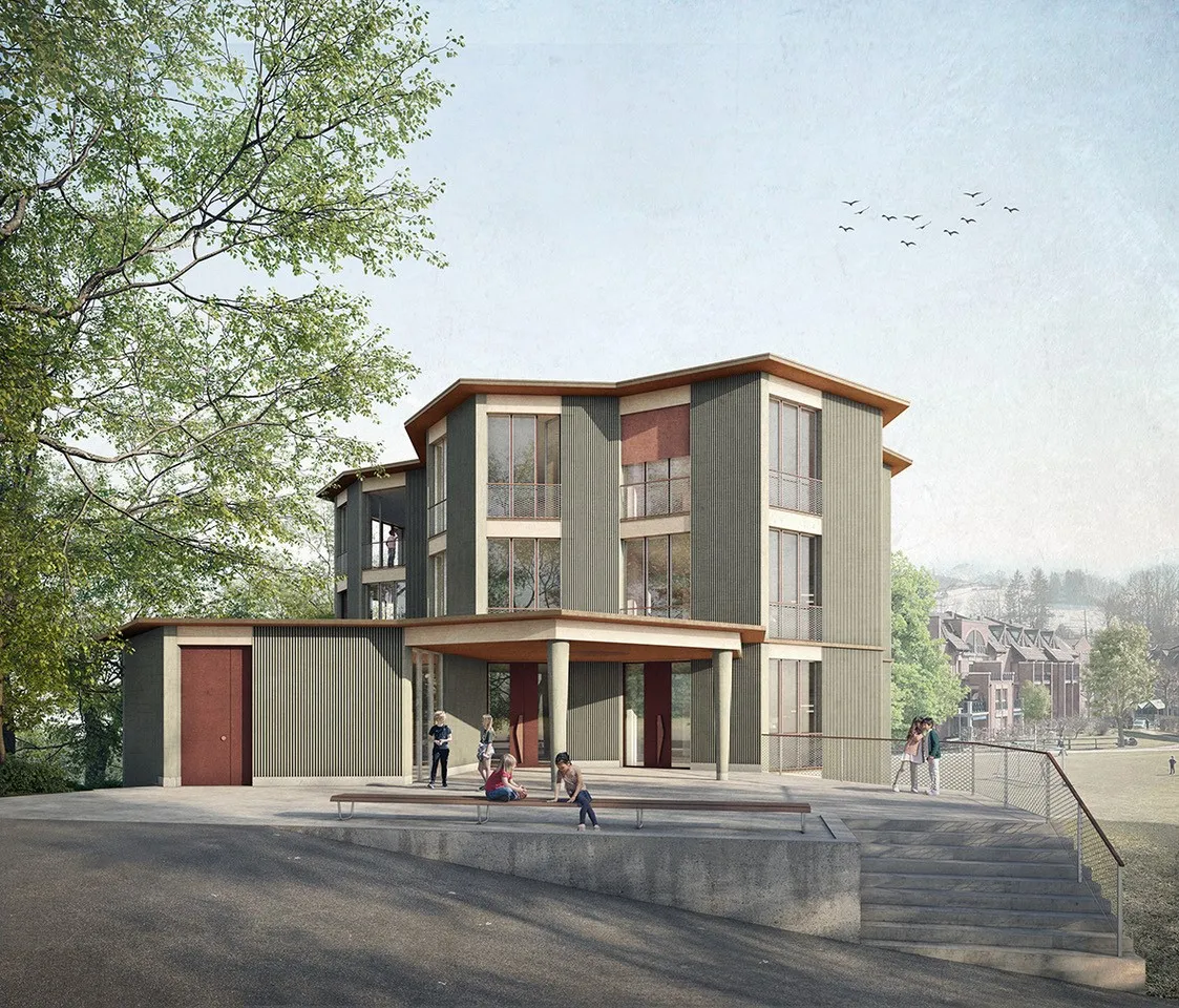 Gebäude mit vielen Fenster. Im Vordergrund sitzen Personen auf einer Bank. Vögel fliegen über dem Dach