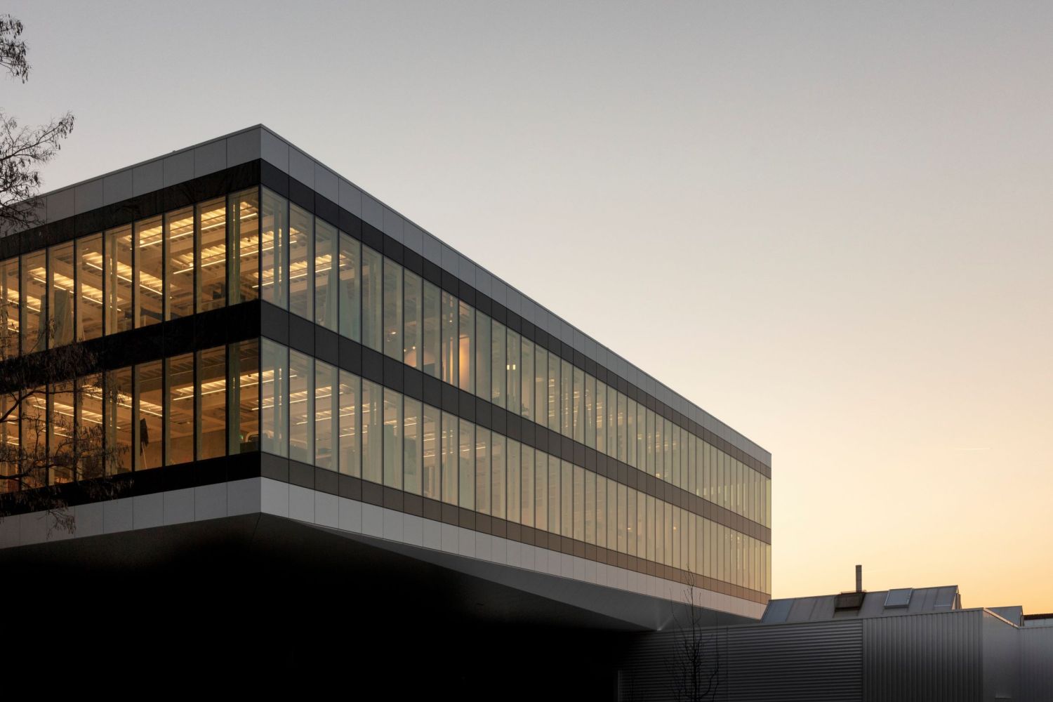 Bühler Innovation Campus CUBIC, Uzwil Gebäude mit grosser Glasfront bei abendlicher Stimmung