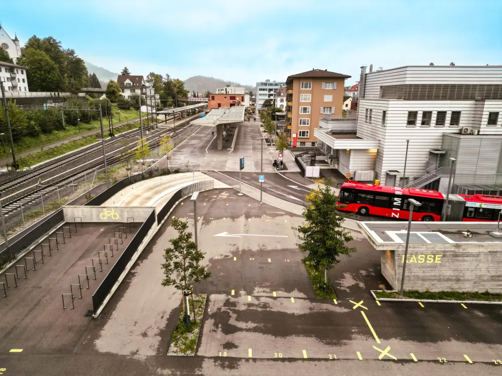 Grosser Platz mit Parkfeldern und einem Bus
