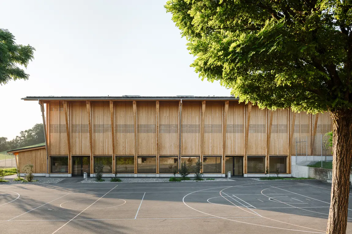 Doppelturnhalle Feltschen Biglen Holzfassade Sportplatz Baum 