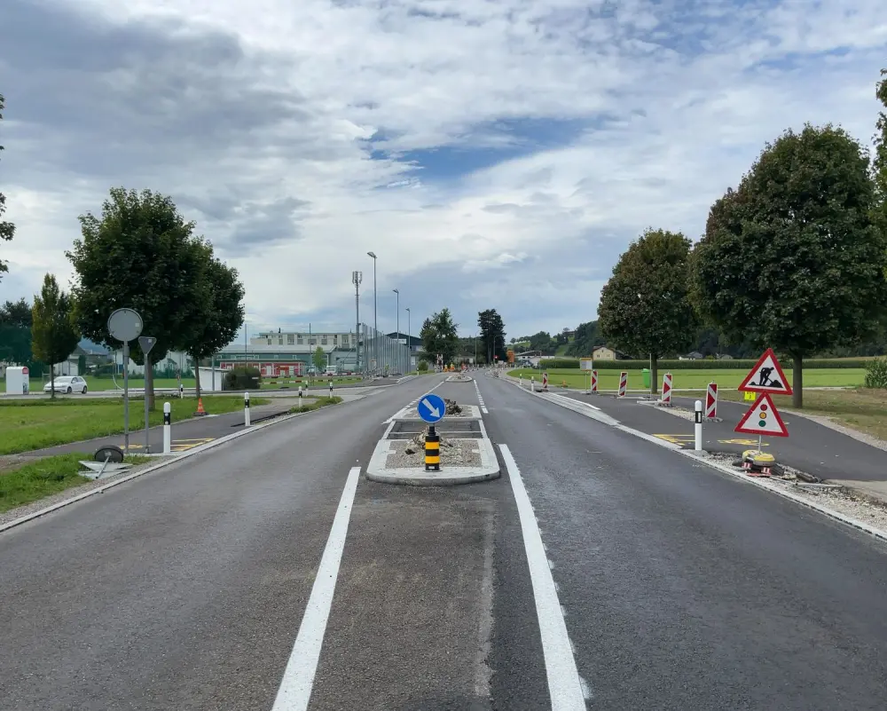 Strasse mit verschiedenen Schildern und einer Verkehrsinsel in der Mitte