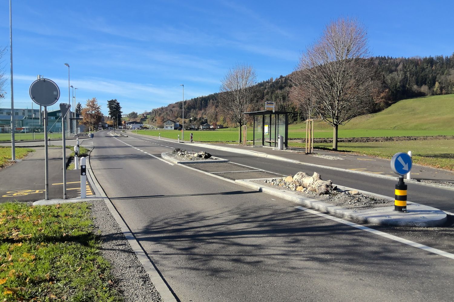 Strasse mit verschiedenen Schildern und einer Verkehrsinsel in der Mitte